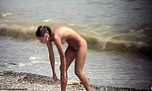 Chica desnuda de cabello oscuro caminando desnudita en una playa