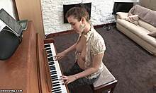 Brunette yang playful dengan payudara yang kencang bermain piano tanpa baju