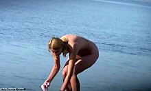 胸部丰满的金发女郎在裸体海滩上做事,看起来很性感